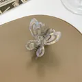 Close-up of a pearlescent hollow butterfly hair claw clip with glossy finish - Gray