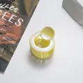 Dettaglio di una molletta per capelli rotonda giallo chiaro glitterata da 3,5 cm lucida - Bianco Sporco