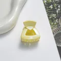 Dettaglio della molletta a triangolo giallo chiaro con finitura glitterata e denti in plastica - Bianco avorio