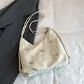 Creamy white shoulder bag with silver butterfly accents and pleated texture - White