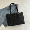 Sac fourre-tout noir minimaliste avec texture plissée et clous argentés sur fond à carreaux - Noir