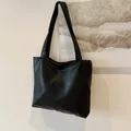 Minimalistische schwarze Tragetasche aus Kunstleder mit dezenter Litschistruktur - Schwarz