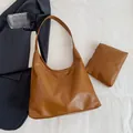 Brown soft PU leather hobo tote bag and matching pouch on a minimalist background - Brown