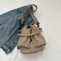 Minimalistische kaki bucket bag met brede schouderband op een spijkerjasje - Khaki