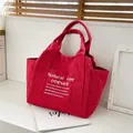 Chic rose red canvas tote bag with white lettering and sturdy shoulder straps - Red