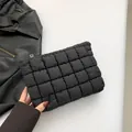 Quilted black pouch with puffer texture and gold-tone zipper, handheld style - Black