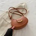 Caramel brown saddle shoulder bag with a gold crescent buckle and smooth PU finish - Brown