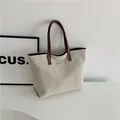 Minimalistische beige Segeltuch-Tasche mit dunkelbraunen Riemen und Metallplakette - Braun