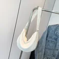 White pleated crescent shoulder bag with crinkled texture on a silver hanger - White