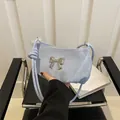 Sac hobo plissé bleu clair avec nœud argenté et perles sur fond minimaliste moderne - Bleu