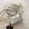 Zilveren metallic halvemaantas met strikgesp op een beige getextureerde jas - Zilver
