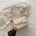 Beige kleine quadratische Umhängetasche aus Leder mit minimalistischem Klappendesign - Gebrochenes Weiß