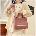 Close-up of pink corduroy tote bag with front pocket and adjustable shoulder strap - Pink