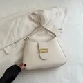 Minimalist beige moon-shaped shoulder bag with gold metal buckle on smooth leather finish - White