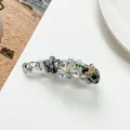 Detail einer Bananenspange mit marmorierten blauen Blüten und funkelnden Kristallsteinen - Marineblau