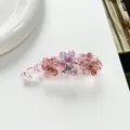 Dettaglio ravvicinato della clip a banana a fiore rosa con cristalli su sfondo bianco - Rosa
