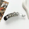 Vue détaillée de la pince banane fleurie avec strass brillants et pétales perlés - Gris