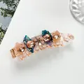 Detail of acetate banana hair clip featuring champagne floral crystal embellishments - Nude