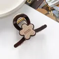 Détail d'une pince à cheveux de 7 cm en résine avec fleur beige et lettrage français - Brun Foncé