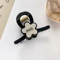 Détail de la pince à cheveux fleur avec texte Barrette La France et décor perlé - Noir