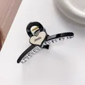 Detail of a black hair claw clip featuring a beige heart with Barrette La France text - Black