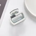 Dettaglio del fermaglio rettangolare color crema e blu con strass brillanti incastonati - Bianco