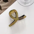 Detail of olive green acrylic hair claw clip with champagne rhinestones and gold spring - Gold