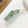 Makroaufnahme der großen Bananenspange mit Resin-Blumen und glitzernden Strasssteinen - Grün