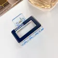 Detailed view of a small square hair claw clip with blue rhinestones and acrylic finish - Dark Blue