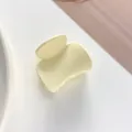 Close-up of matte cream yellow small hair claw clip for girls ponytail styling - Off White