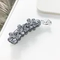 Dettaglio macro della clip per capelli grigia con fiori glitter argento e strass chiari - Grigio