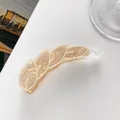 Detailed view of leaf-shaped champagne banana clip made of textured acetate material - Off White