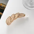 Detail of leaf-shaped banana hair clip with pearlescent marble texture and gold trim - Khaki