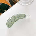 Macro detail of leaf-shaped banana hair clip in iridescent green acrylic finish - Green