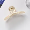 Detail of cream translucent hair claw clip with crossed design and gold metal spring - 11cm / Off White