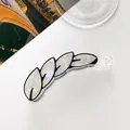 Detail of banana hair clip with white pearlescent leaf design and black outlines - Black