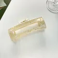 Dettaglio macro della grande pinza per capelli rettangolare in acetato marmorizzato - Giallo