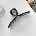 Detail der 13cm großen Haarklammer mit schwarzer Streifenoberfläche und klaren Zähnen - Schwarz