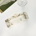Dettaglio della grande pinza per capelli rettangolare in acetato con venature marmo beige - Grigio