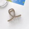 Detailed view of a champagne glitter hair claw clip with cross design on white surface - Khaki