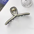 Makro-Detail einer 13cm gestreiften Haarklammer mit schwarzem Rahmen und Goldfeder - Gebrochenes Weiß
