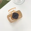 Detailed close-up of amber acrylic hair claw clip with Barrette La France lettering - Light Khaki