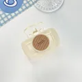 Detail view of cream hair claw clip with brown Barrette La France circular disc detail - Off White