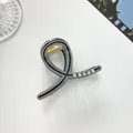 Detalle de mini pinza gris para el pelo con pedrería y muelle dorado en fondo blanco - Gris