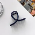 Macro shot of dark blue glitter hair claw clip with twisted ribbon design and metal spring - Dark Blue