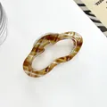 Detalle de pinza para el pelo tipo nube ámbar con diseño hueco y resorte de metal resistente - Dorado