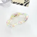 Foto macro de una pinza para el pelo con estampado de cuadros de colores sobre blanco - Multicolor