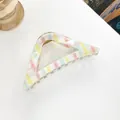 Macro detail of geometric hollow triangle hair claw clip with colorful macaron stripes - Colorful