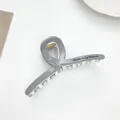 Detailed view of grey hair claw clip featuring Barrette La France text and metal spring - Gray