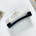Detail showing the rectangular geometric hair claw clip with pearlescent shell texture - Large / Black